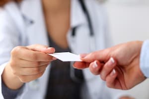 Nurse handing over insurance card
