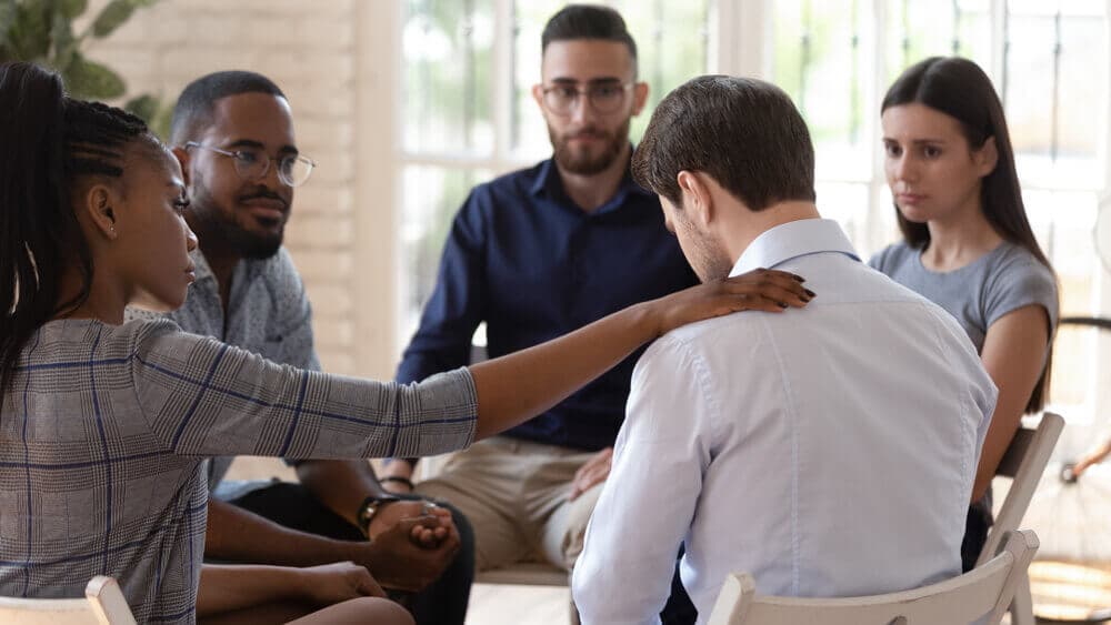 people sitting in group therapy discussing alcohol misuse